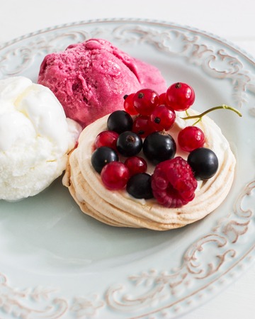 Three dessert ice cream berry pavlova nests kitchen wooden table selective focus.の写真素材
