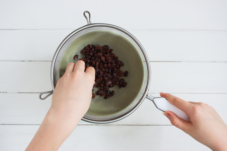 Raisins sieve stainless steel green bowl overhead.の写真素材