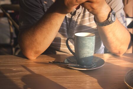 Evening latte cups wooden table caucasian white man.の写真素材