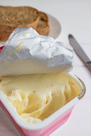 Soft cheese open package knife white background.の写真素材