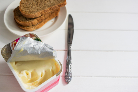 Soft cheese open package knife white background.の写真素材