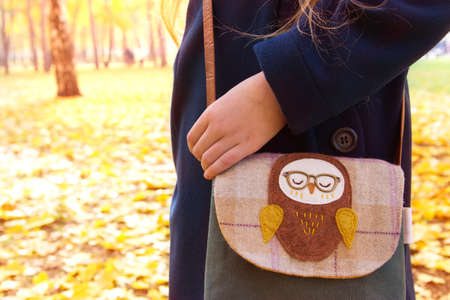 Little girl walks in park with owl handbag.の写真素材