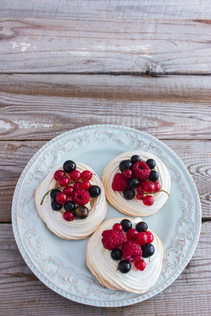 Modern chic mini pavlova cake kitchen wooden table selective focusの写真素材