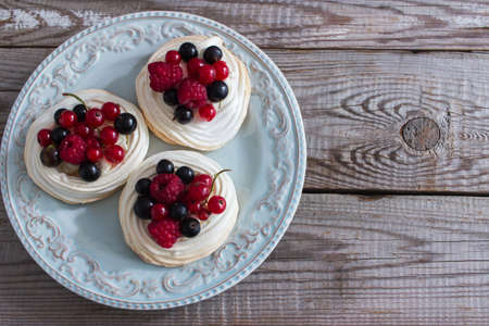 Fresh trendy mini pavlova cake kitchen wooden table selective focusの写真素材