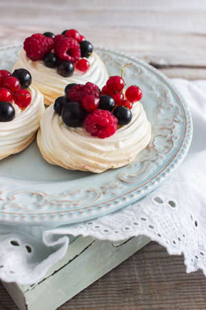 Fresh chic mini pavlova cake kitchen wooden table selective focusの写真素材
