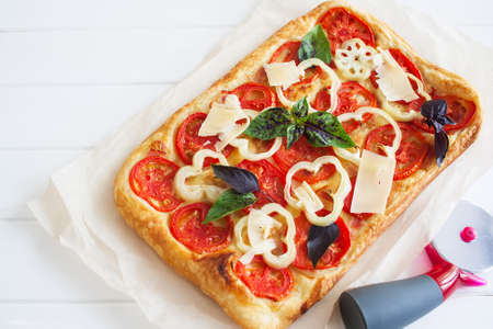 Ruddy rectangle hot pizza bacon white wooden background paper selective focus.の写真素材