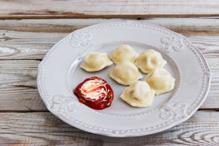 Russian dumplings meat dumplings with sauce wooden background.の写真素材