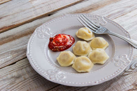 Russian dish meat dumplings pelmeni wooden background.の写真素材