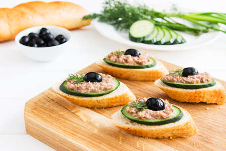 Open tuna sandwiches with cucumber on cutting board.の写真素材