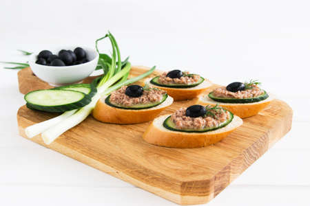 Open tuna sandwiches with cucumber on cutting board.の写真素材