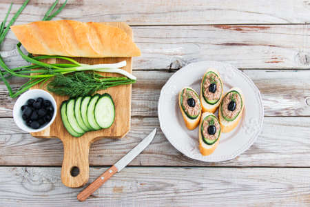 Open tuna sandwiches with cucumber on cutting board.の写真素材
