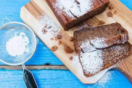 Banana bread with sugar powder on wooden background.の写真素材
