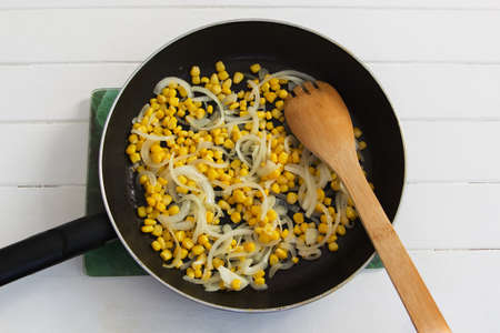 Fried corn onion pan white wooden backgroundの写真素材
