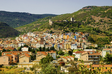 Beautiful landscape in Bosa with green hills, colorful houses of the district Sa Costa and and the Castle - il Castello di Serravalle, also called il Castellos di Malaspina in Sardinia, Italy.のeditorial素材