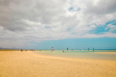 Windsurfers on the beach Playa de Sotavento in a cloudy day in summer on the Canary Island Fuerteventura, Spain.の写真素材