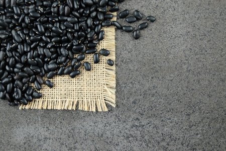 Black dried beans on a burlap cloth and dark-grey background.の写真素材
