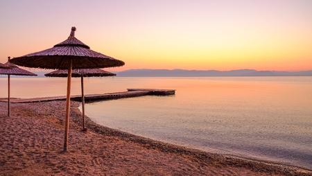 View on the beach in Moraitika with sun umbrellas on the sunrise on the the island Corfu, Greece.の写真素材
