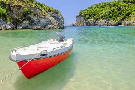 Red boat in emerald water on the beach Paleokastritsa on the island Corfu, Greece.の写真素材