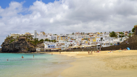 MORRO JABLE, FUERTEVENTURA, SPAIN - JUNE 14, 2017: View on the beach Playa de Matorral and village Morro JAble with unknown tourists on the Canary Island Fuerteventura, Spain.のeditorial素材