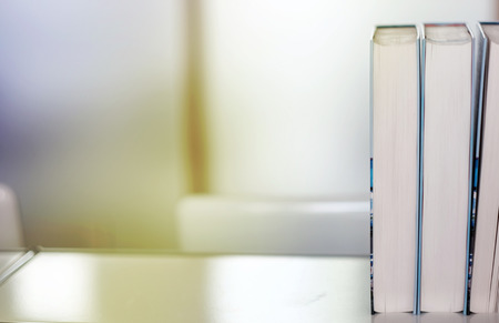 Stack of books on a shelf in a library.