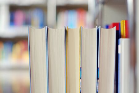 Stack of books on a shelf in a library.