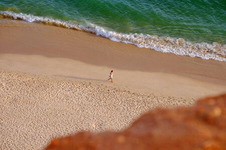 FALESIA, ALGARVE, PORTUGAL - MAI 25, 2019: View on the beach Praia da Falesia Barranco das Belharucas and unknown person walking along it.のeditorial素材
