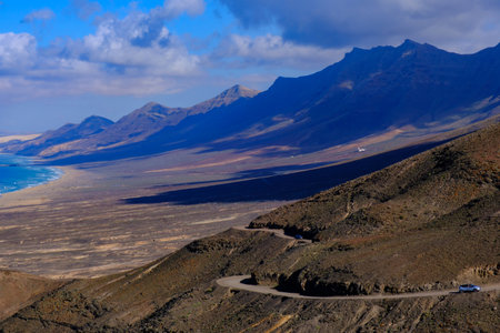 Amazing aerial view on Cofete beach and a curved road on Fuerteventura, Spain - Canary Islands