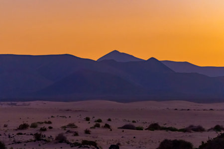 View of the dunes of Corralejo and silhouetted hills at sunset on the Canary Island of Fuerteventura, Spain.の写真素材