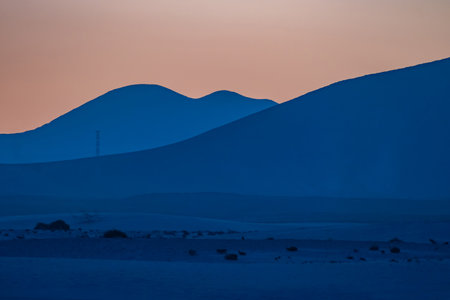 View of the dunes of Corralejo and silhouetted hills at sunset on the Canary Island of Fuerteventura, Spain.の写真素材