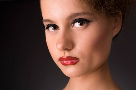 Close-up portrait of serious-looking woman on a black background