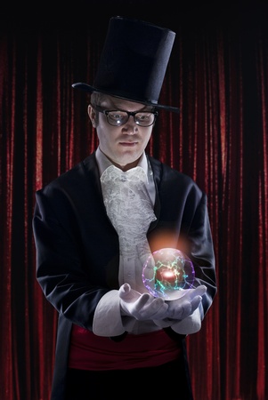 dark portrait of the magician on stage. Holding a luminous sphere. の写真素材