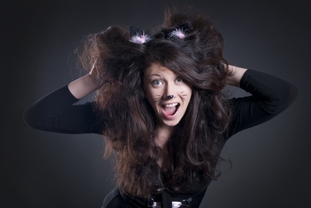 dark studio portrait of a shocked girl dressed as a catの写真素材