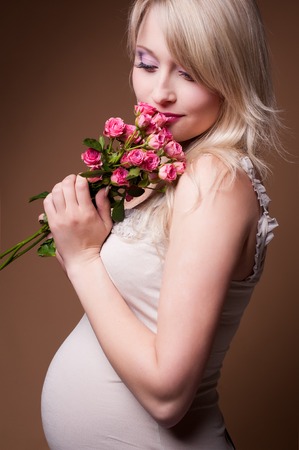Photo portrait of a lovely young pregnant woman in a photo studio.