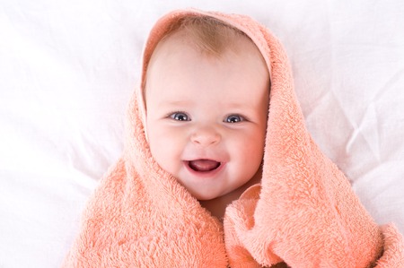 A cute baby wrapped in a towel.の写真素材