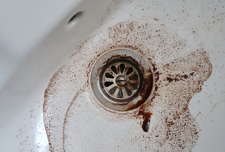 Dirty water going down the drainの写真素材