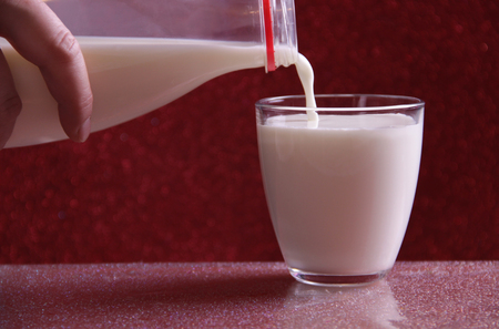 Pouring milk in a glassの写真素材