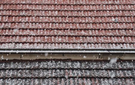 Snow falls on the roof of the house