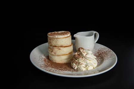 Fluffy Japan souffle pancakes, coffee syrup black background with copy spaceの写真素材
