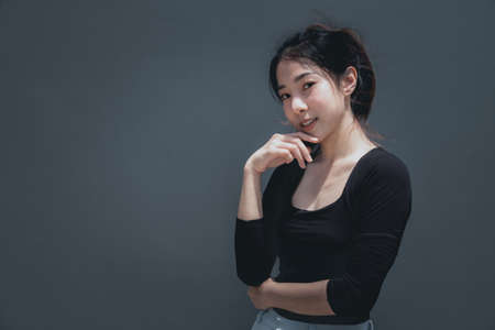 Young beautiful asian woman portrait smiling isolated on grey background with copy spaceの写真素材