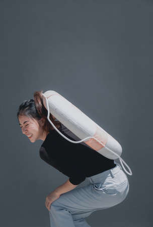 Young beautiful woman portrait with swim ring isolated on grey background outdoor conceptの写真素材