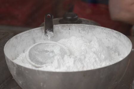 powdered sugar in a metal bowl with a sieveの写真素材