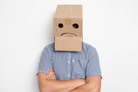 a man with a cardboard box on his head, a sad smileyの写真素材