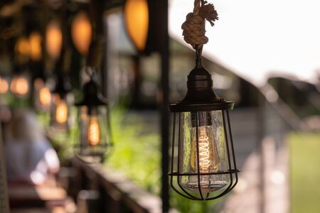 Vintage decor lighting. Metal lamp with antique lamp hanging on a thick ropeの写真素材