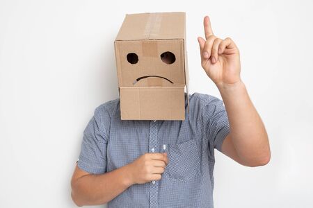 a man with a cardboard box on his head, a sad smileyの写真素材