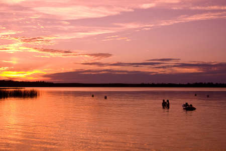 Some people swimming at sunset at Madge Lake in Saskatchewan, Canada.の写真素材