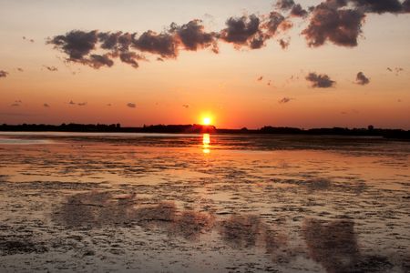 A Canadian prairie sunset on a calm pond.の写真素材