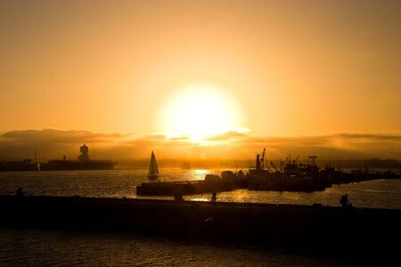 Fishing boats and an aircraft carrier at the piers of the bay in San Diego, California.の写真素材