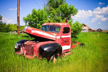 Old rusty red farm truck fading in time.