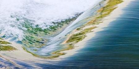 Water flowing down a waterfall with the illuminated reflected in the wavesの写真素材