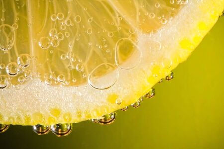 Thin slice of yellow lemon in soda water to form the bubblesの写真素材